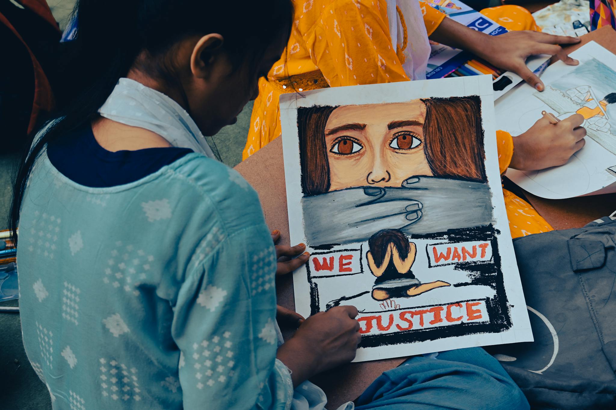 A young girl creates powerful protest art to raise awareness for women's justice in Kolkata, India.
